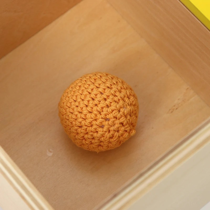 Boîte avec couvercle basculant et balle en tricot